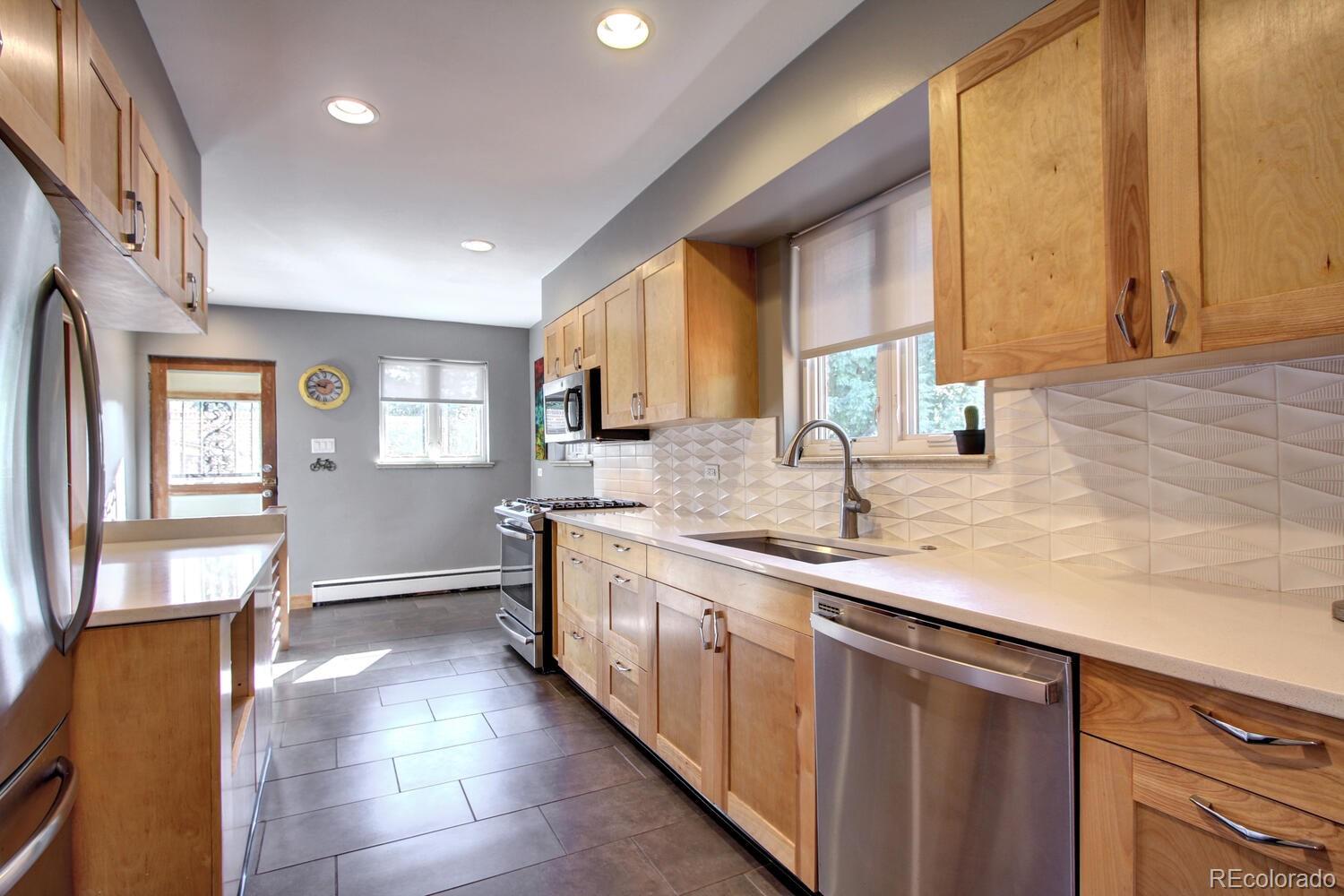 1300 Elm Street Denver, CO 80220 - Photo 11 of 40 a kitchen with stainless steel appliances granite countertop a sink and a stove