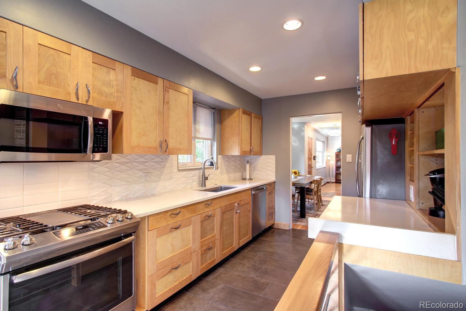 1300 Elm Street Denver, CO 80220 - Photo 15 of 40 a large kitchen with stainless steel appliances granite countertop a stove a sink and a microwave