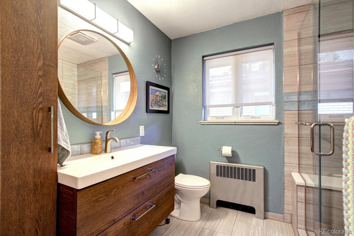 1300 Elm Street Denver, CO 80220 - Photo 19 of 40 a bathroom with a sink a mirror a toilet and a window
