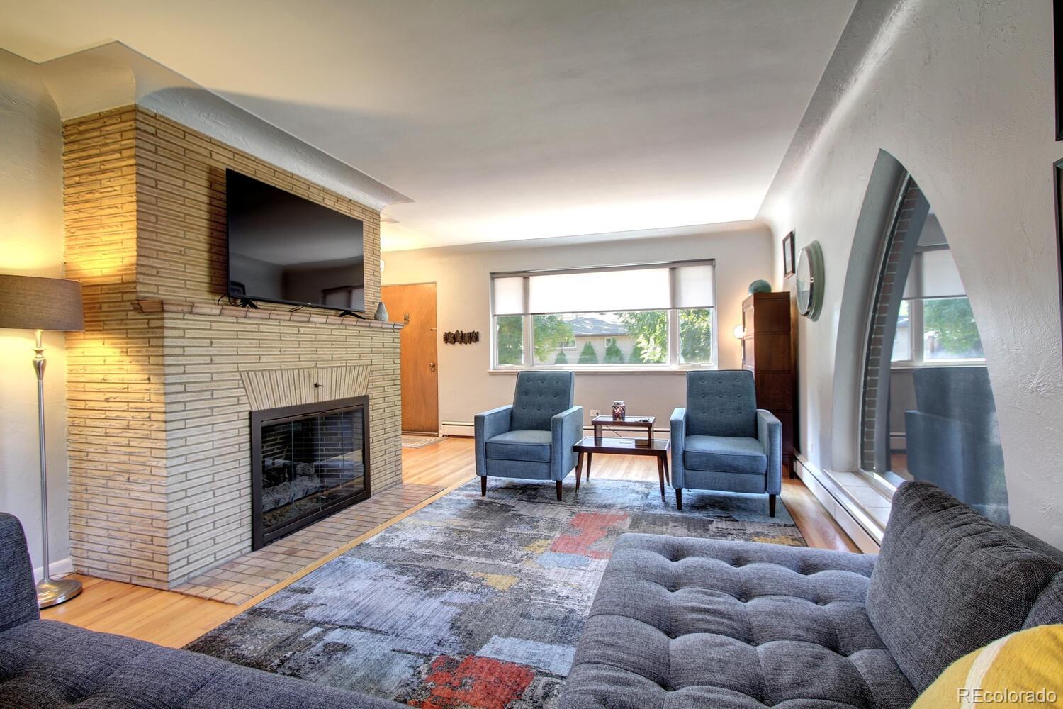 1300 Elm Street Denver, CO 80220 - Photo 6 of 40 a living room with furniture a flat screen tv and a fireplace