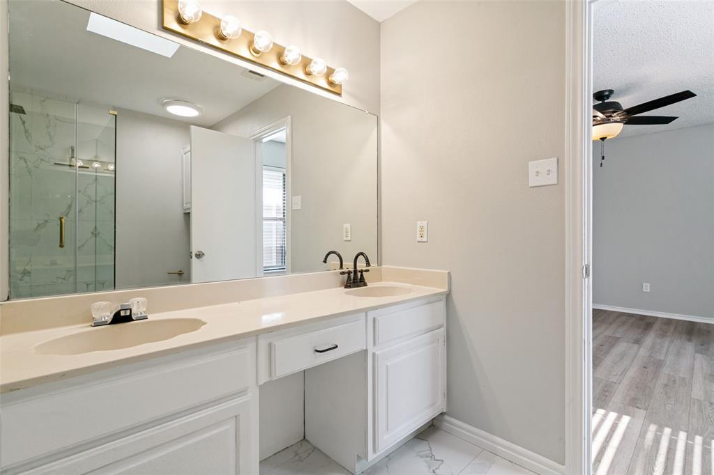 1712 East Peters Colony Road Carrollton, TX 75007 - Photo 21 of 25 Dual vanity with integrated sinks, light-toned countertop, and white cabinetry