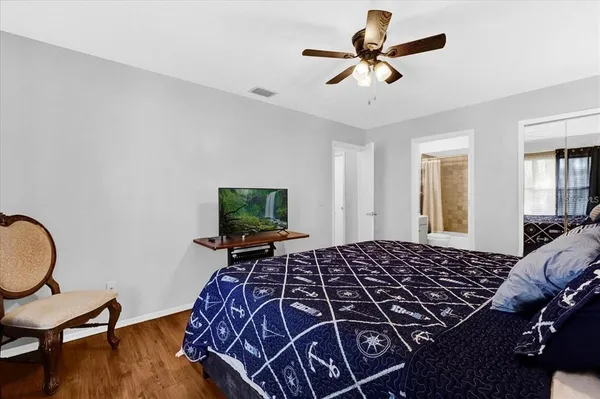 a bedroom with bed and wooden floor