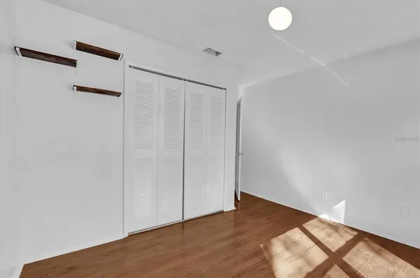 a view of a big room with wooden floors and windows