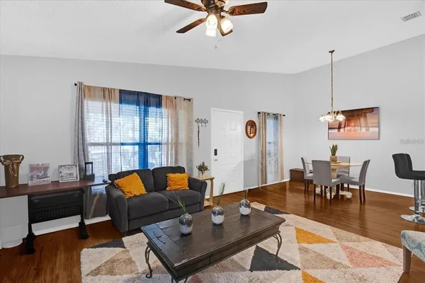 a living room with furniture and a wooden floor