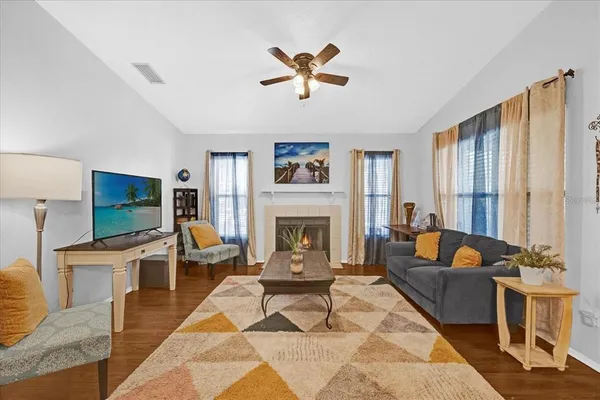 a living room with furniture a fireplace and a flat screen tv