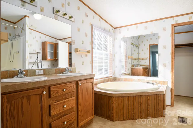 a spacious bathroom with a tub sink shower and mirror