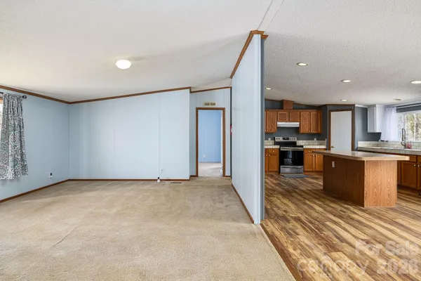 a view of kitchen with refrigerator stove and wooden floor