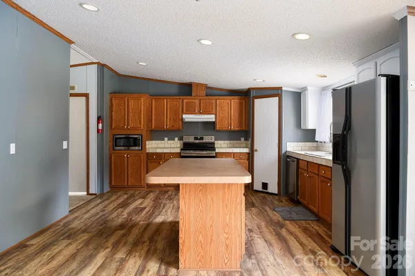 a kitchen with granite countertop stainless steel appliances and refrigerator