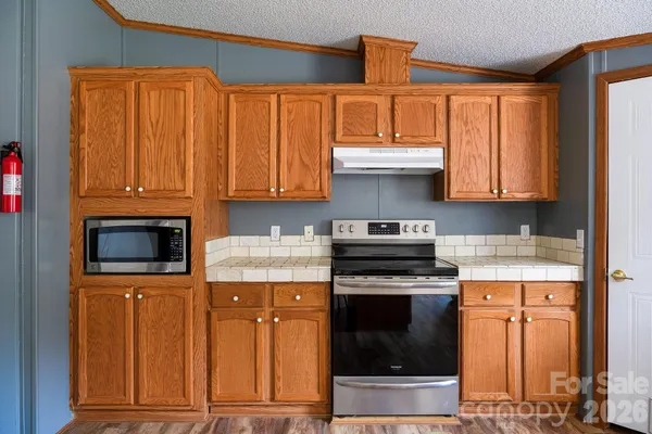 a kitchen with stainless steel appliances granite countertop a stove and a microwave