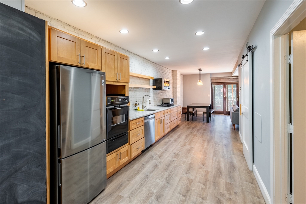 a large kitchen with a large window and stainless steel appliances