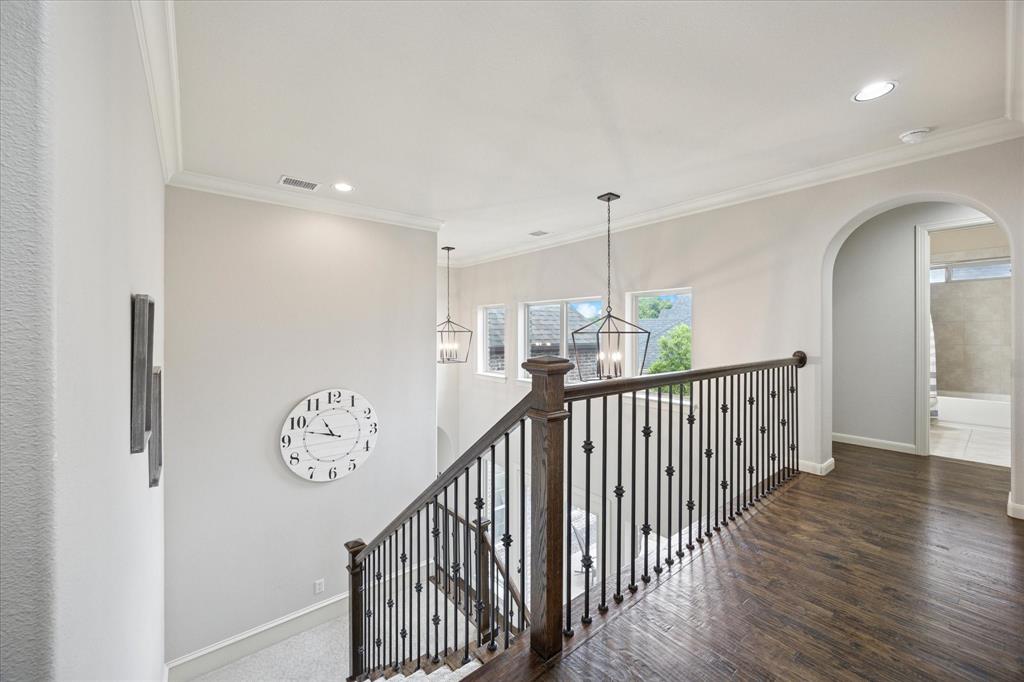 580 Butchart Drive Prosper, TX 75078 - Photo 22 of 40 Hallway with a chandelier, baseboards, ornamental molding, wood finished floors, and arched walkways