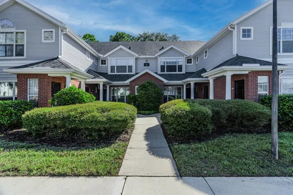 a front view of a residential houses with yard and green space