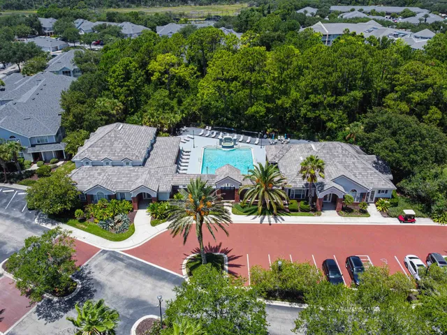 a dining room with wooden floor a chandelier a glass table and chairs