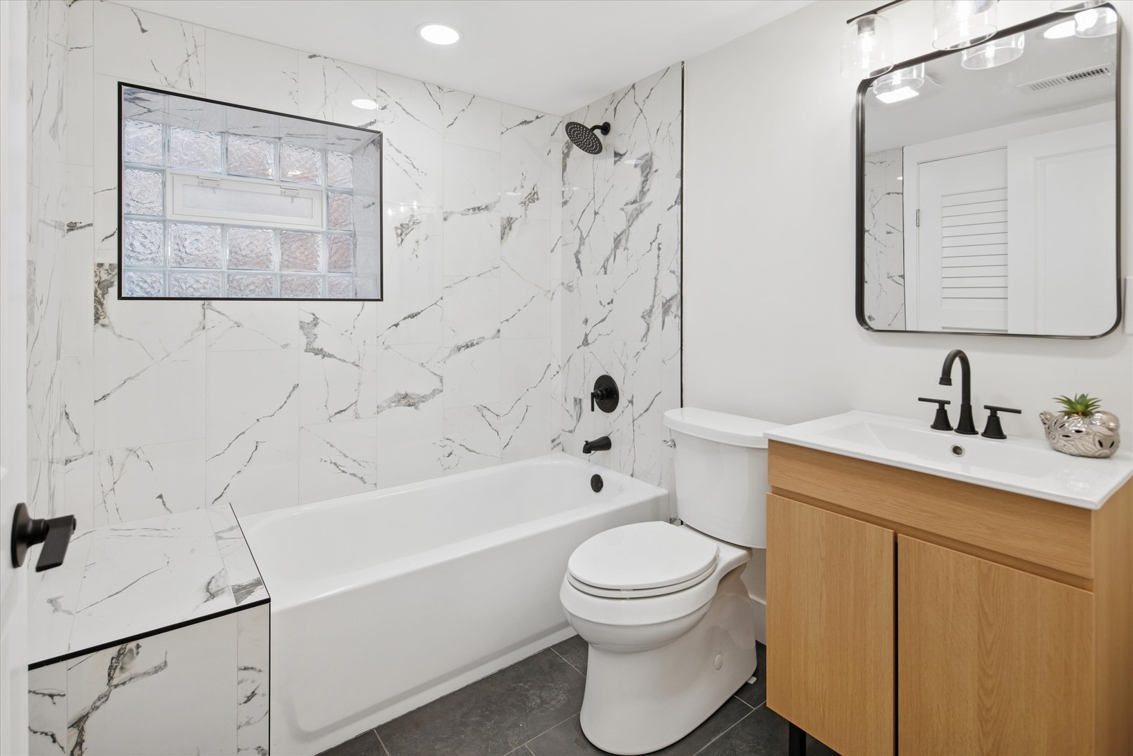 5604 North Mango Avenue Chicago, IL 60646 - Photo 16 of 20 a bathroom with a toilet sink vanity tub and shower