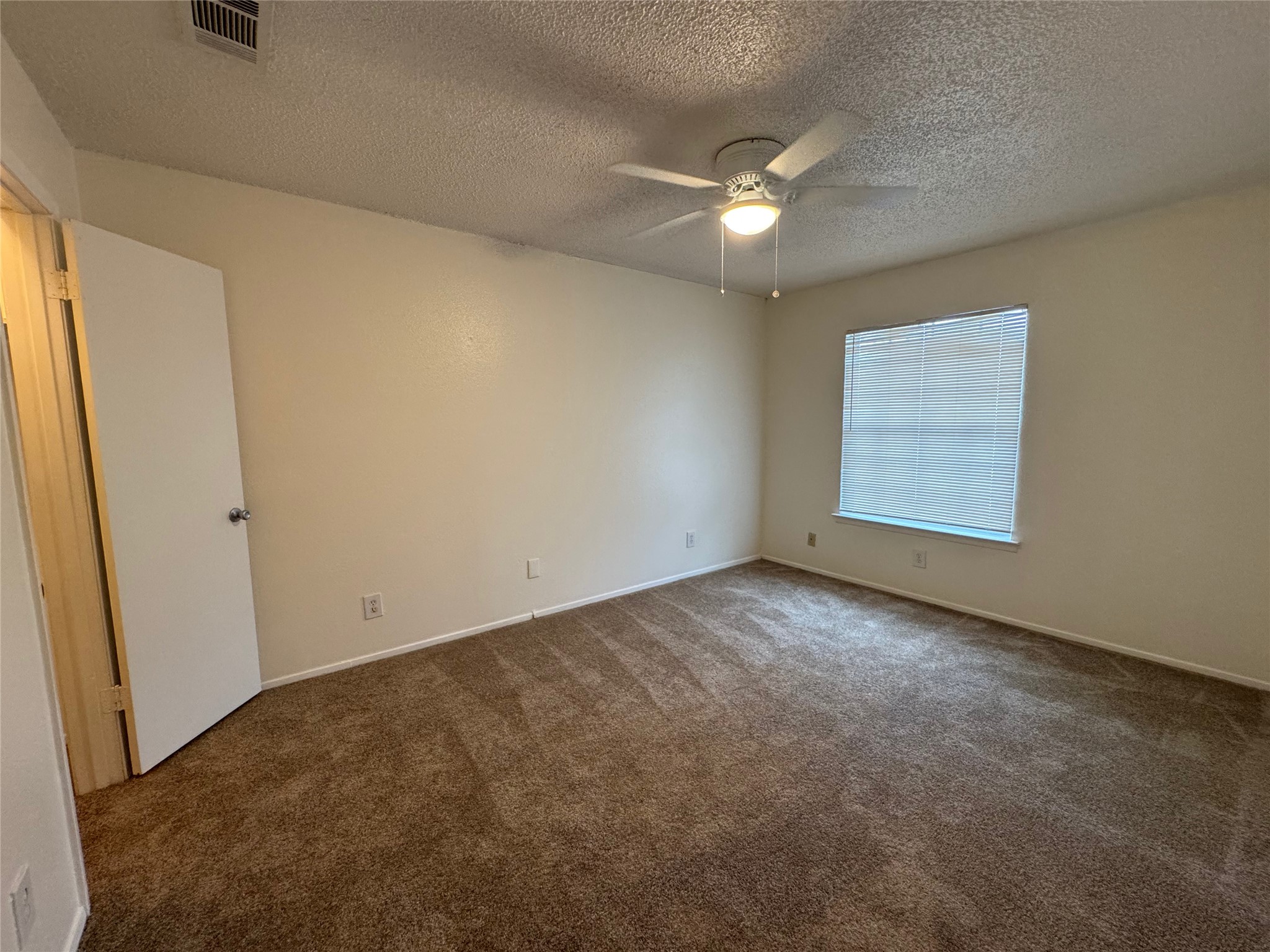 4810 West Wind Trail, Unit 102 Austin, TX 78745 - Photo 16 of 23 an empty room with a ceiling fan and window