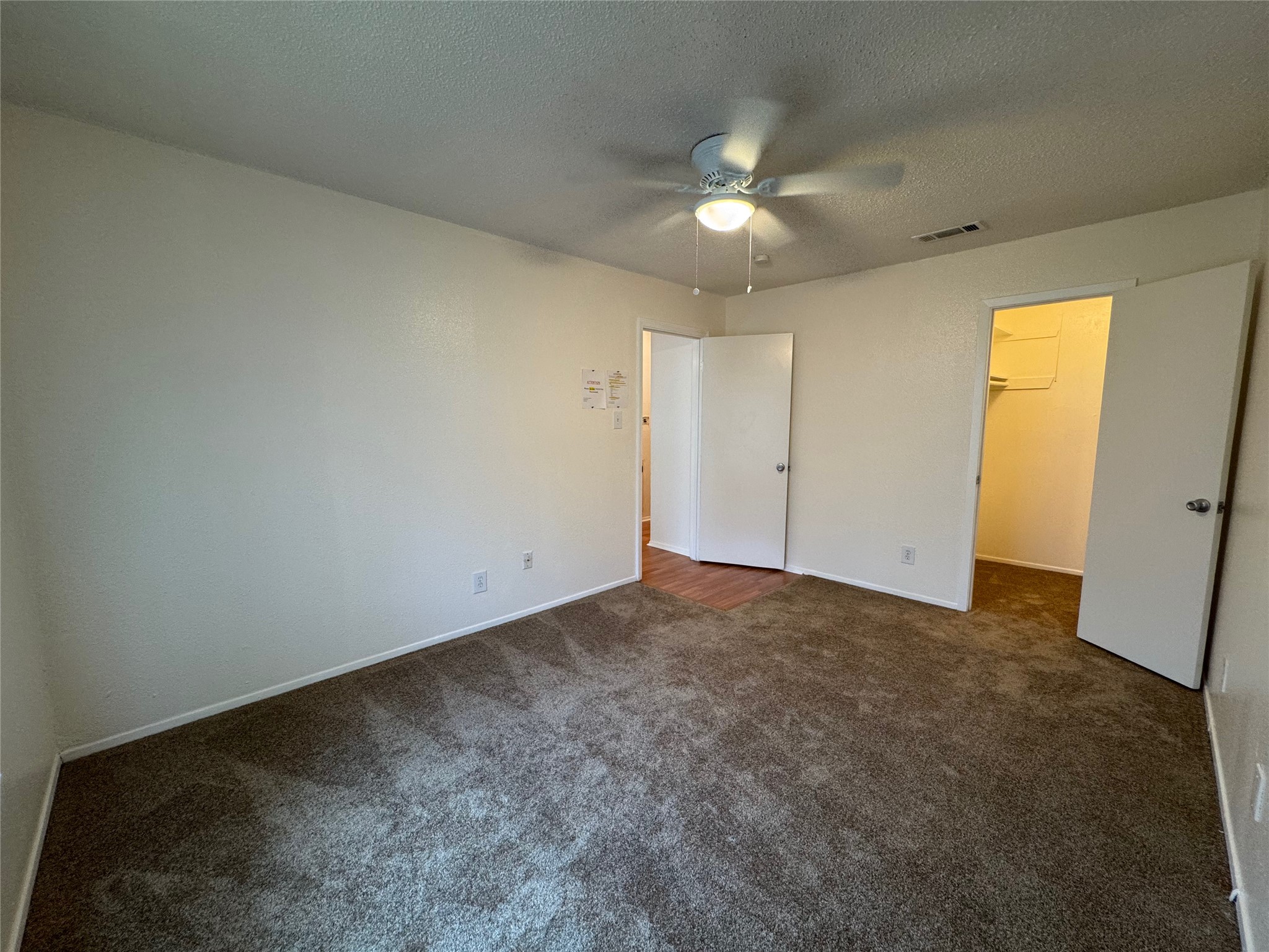 4810 West Wind Trail, Unit 102 Austin, TX 78745 - Photo 17 of 23 an empty room with a chandelier fan and windows