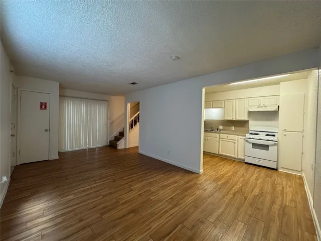 a view of a kitchen with wooden floor and electronic appliances