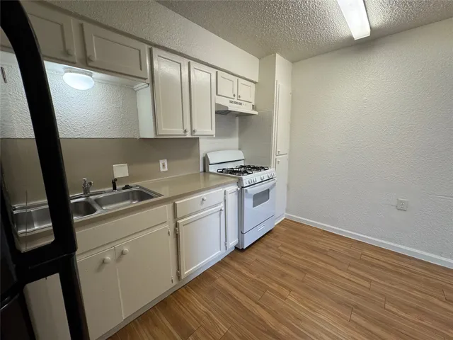 a kitchen with sink cabinets and wooden floor