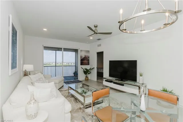 a living room with furniture a flat screen tv and a large window