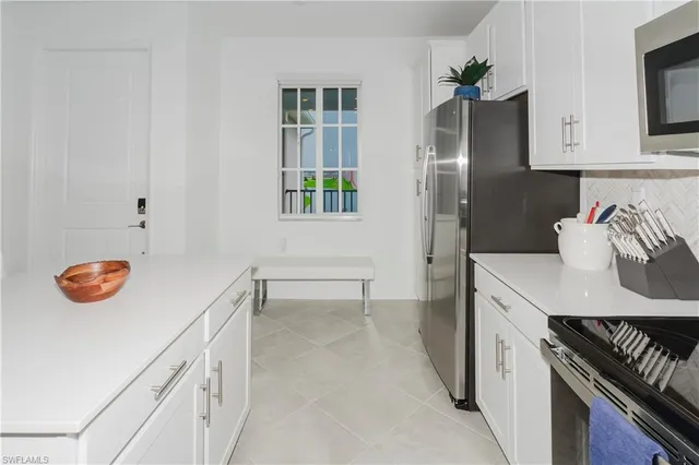 a kitchen with stainless steel appliances cabinets and window