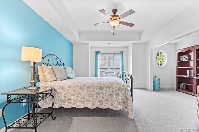 a bedroom with a bed a dresser and painting on the wall