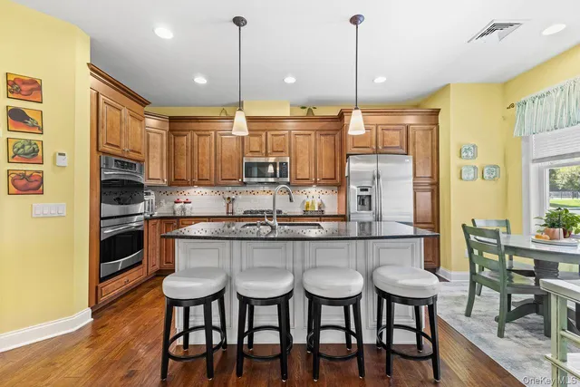a kitchen with kitchen island granite countertop a table and chairs in it