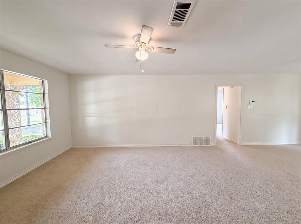 205 West Decatur Street Chico, TX 76431 - Photo 4 of 19 an empty room with chandelier fan and windows