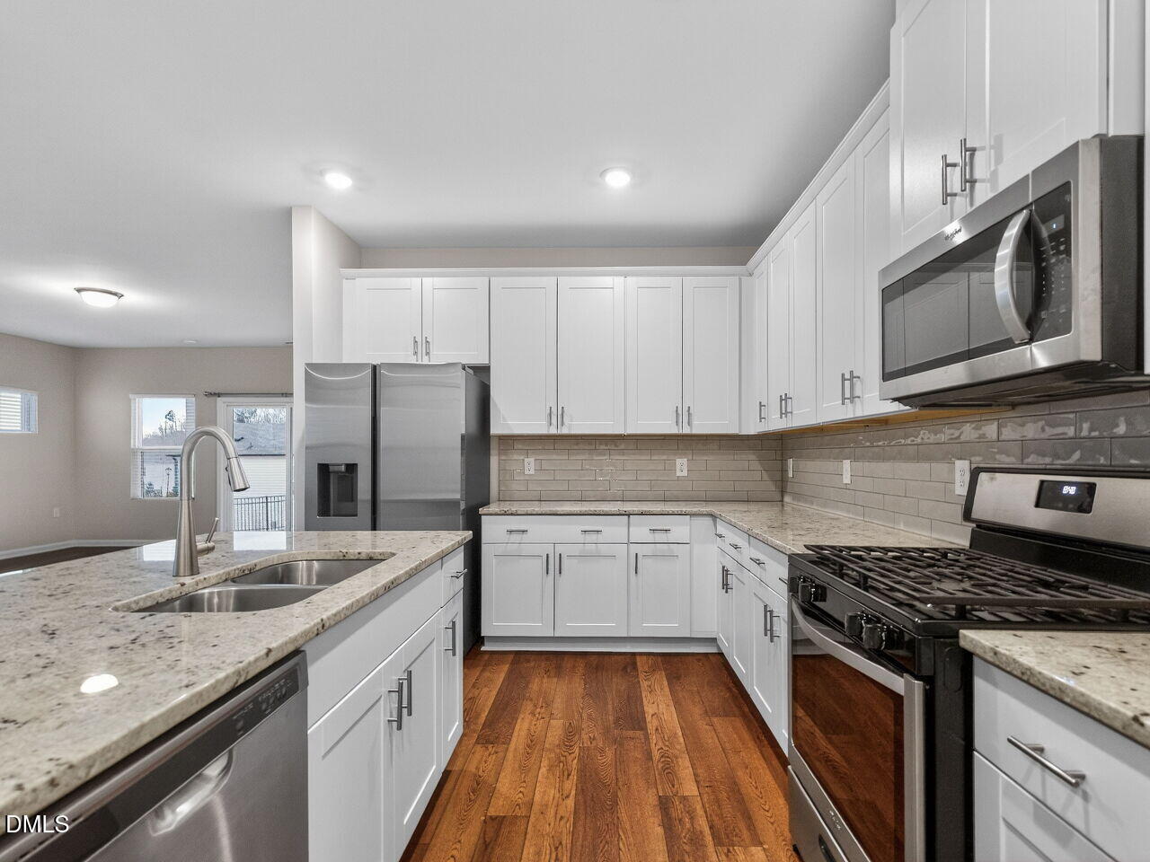 67 Coffee Tree Circle Clayton, NC 27527 - Photo 14 of 34 a kitchen with stainless steel appliances granite countertop a sink stove microwave and cabinets