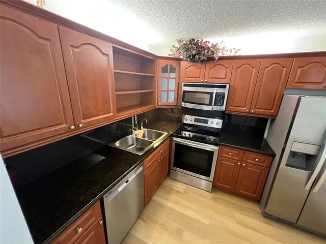 a kitchen with granite countertop a stove and a refrigerator