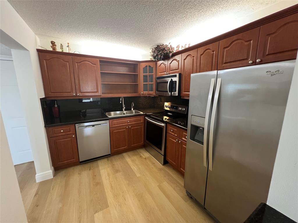 9300 Southwest 8th Street, Unit 422 Boca Raton, FL 33428 - Photo 16 of 38 a kitchen with stainless steel appliances a refrigerator and a sink