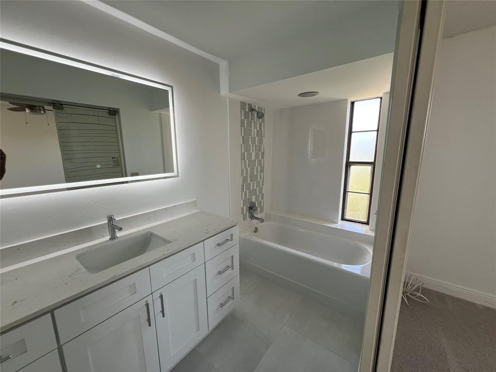 9300 Southwest 8th Street, Unit 422 Boca Raton, FL 33428 - Photo 26 of 38 a bathroom with a tub sink and mirror