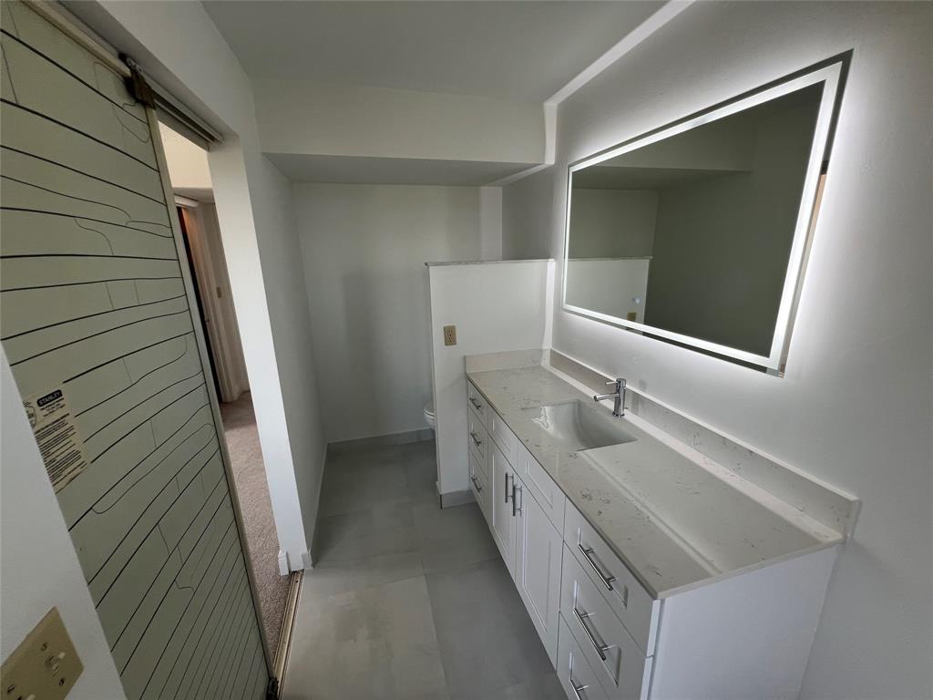 9300 Southwest 8th Street, Unit 422 Boca Raton, FL 33428 - Photo 31 of 38 a bathroom with a double vanity sink and mirror