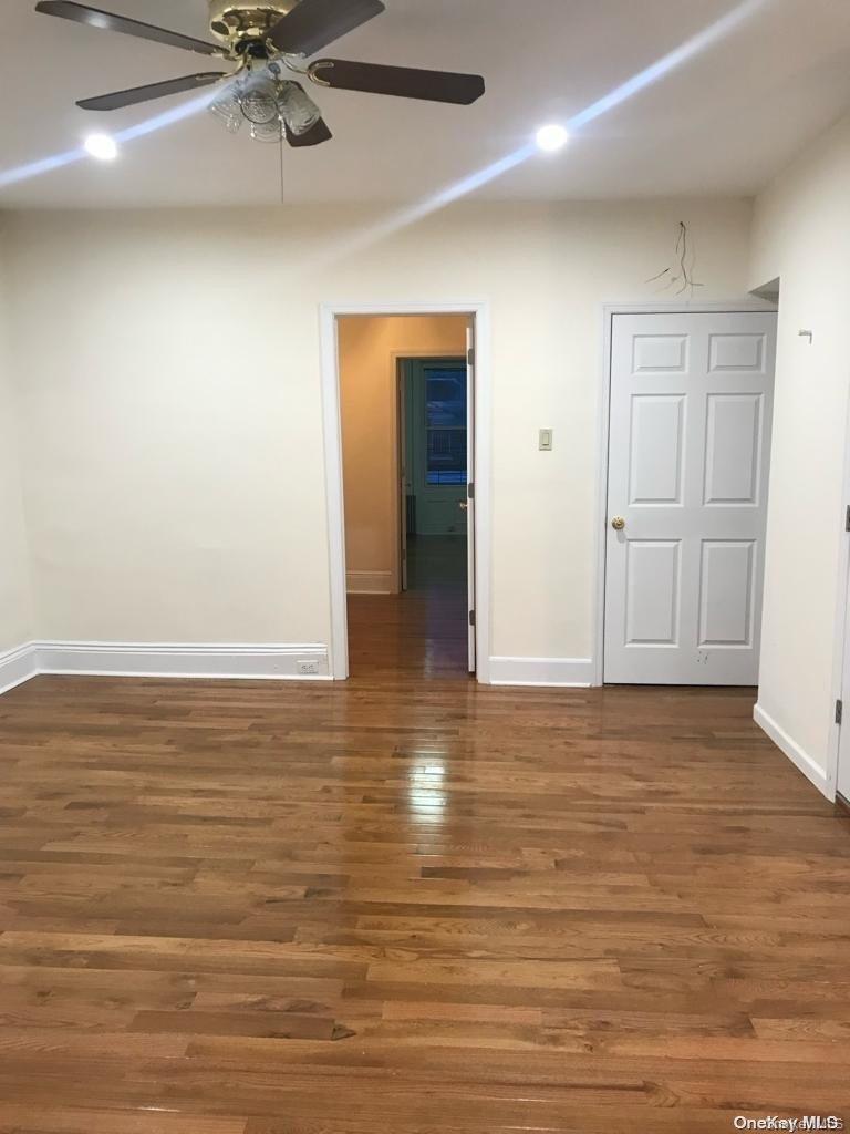 453 Ridgewood Avenue, Unit 2 Brooklyn, NY 11208 - Photo 5 of 11 Empty room with dark wood finished floors and a ceiling fan