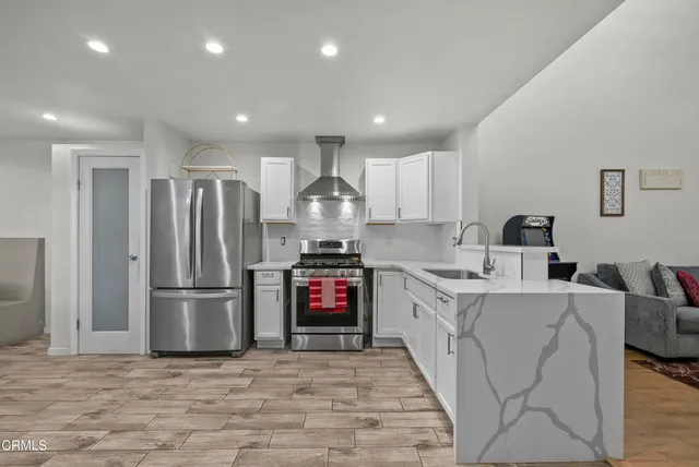 a kitchen with stainless steel appliances granite countertop a refrigerator stove microwave and sink