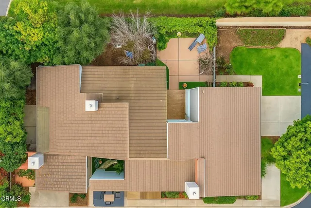 a aerial view of a house with a yard and large tree