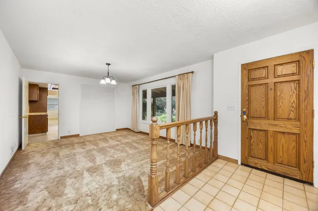 a view of an empty room with window and cabinet