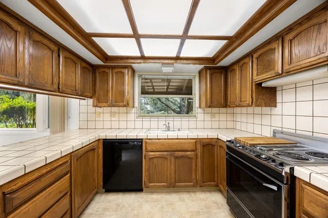 a kitchen with stainless steel appliances granite countertop a sink and a stove
