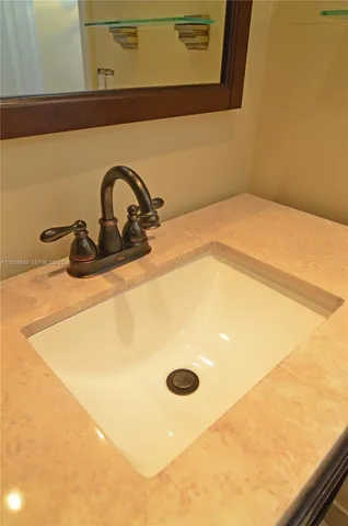 a bathroom with a granite countertop sink a mirror and a bathtub