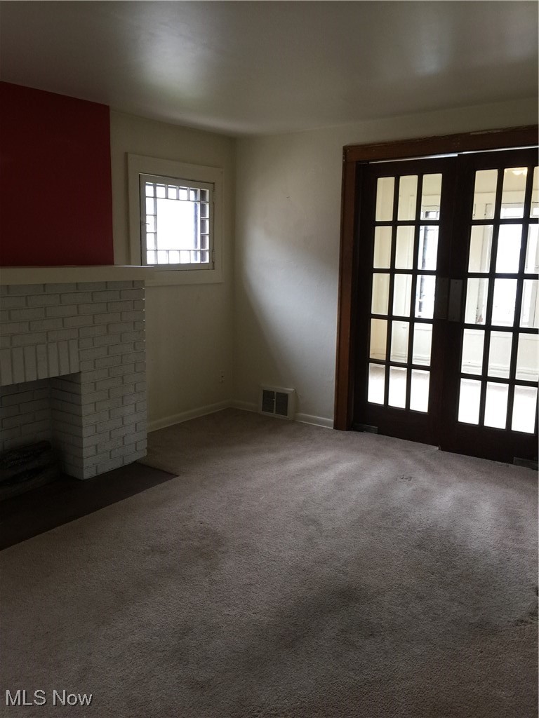 276 Merriman Road Akron, OH 44303 - Photo 12 of 24 Unfurnished living room featuring carpet and a brick fireplace