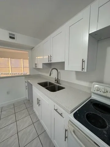 a kitchen with a sink cabinets and a stove