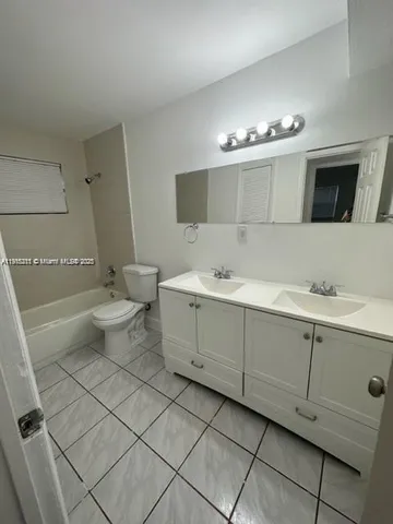 a bathroom with a double vanity sink mirror and toilet