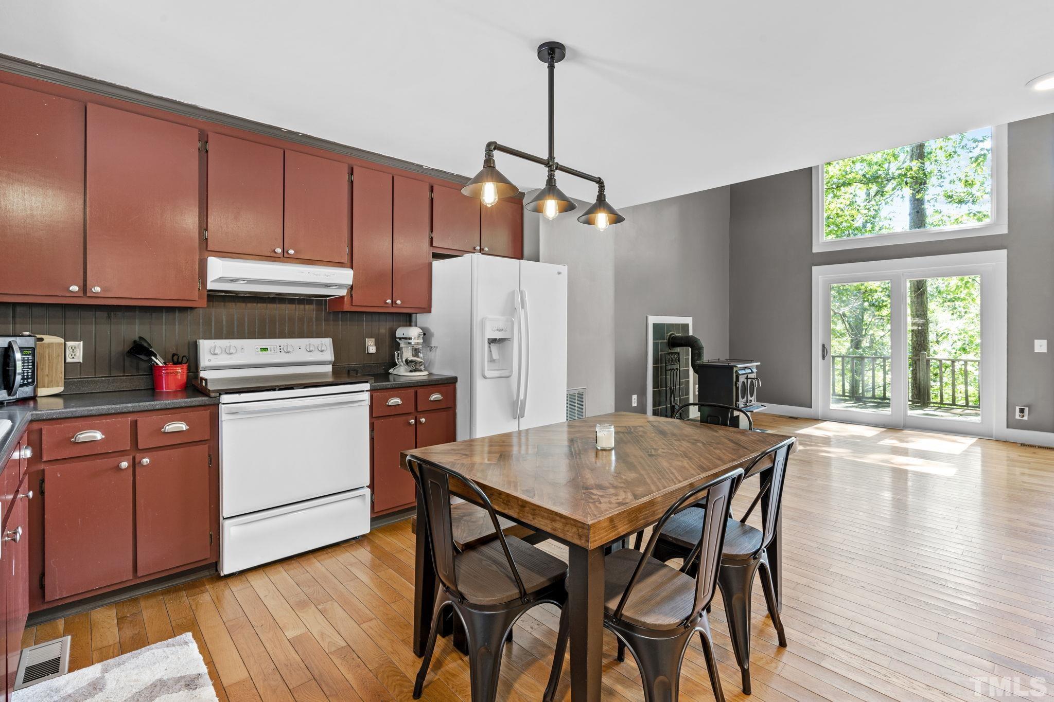 6906 Cassam Road Bahama, NC 27503 - Photo 5 of 22 a kitchen with a wooden table chairs and refrigerator