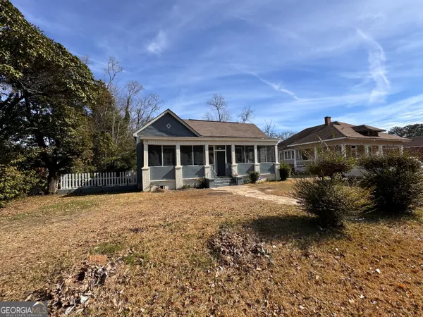 a front view of house with yard and trees in the background