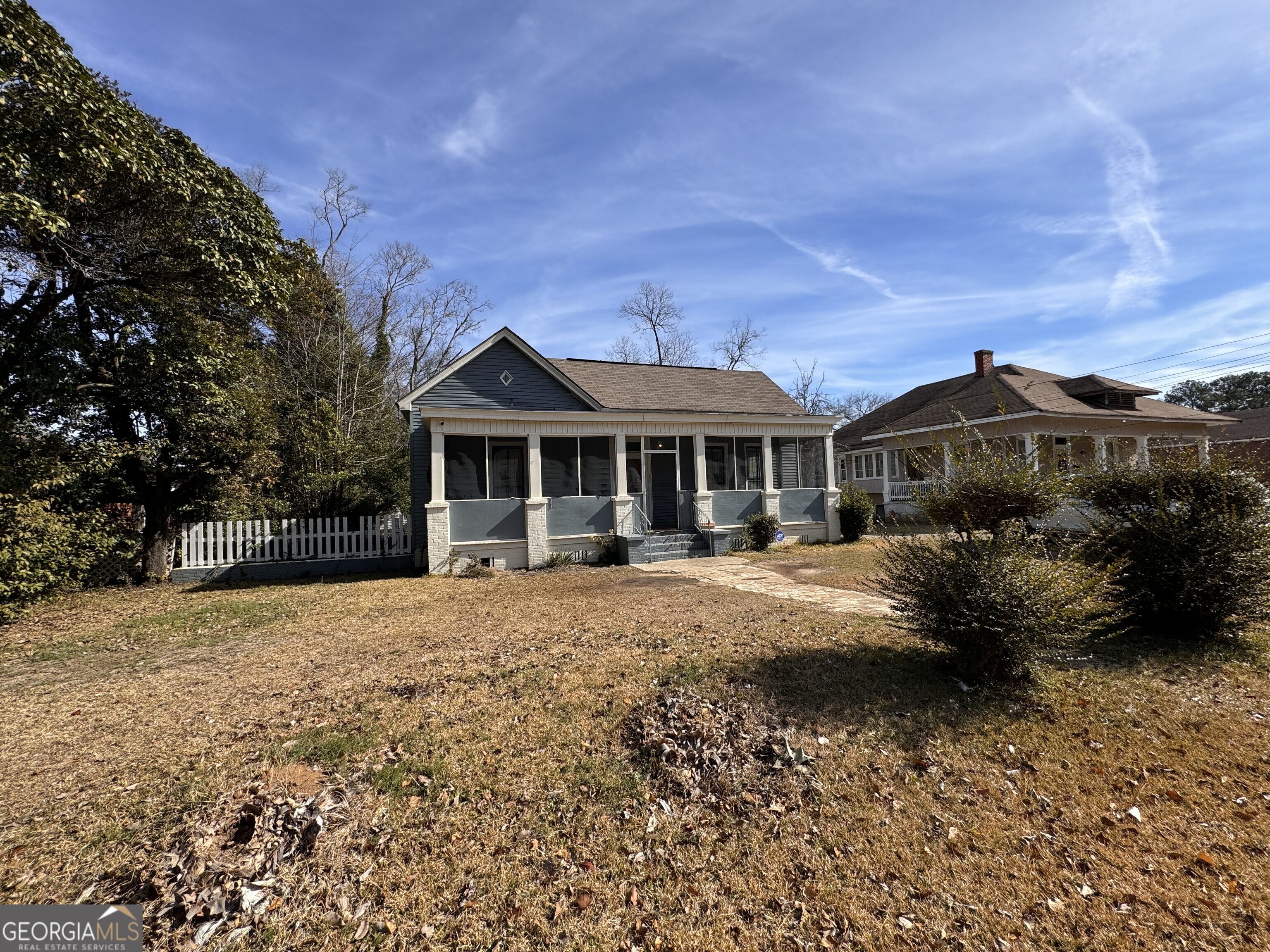 a front view of house with yard and trees in the background