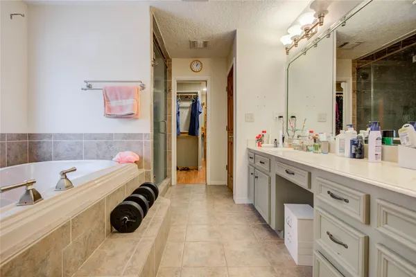 a spacious bathroom with a tub sink and mirror