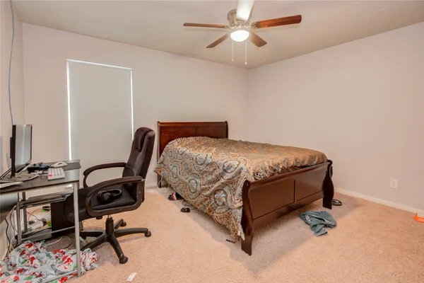 a bedroom with dresser and a window