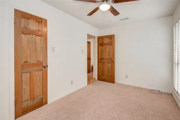 a spacious bedroom with a bed and a chandelier