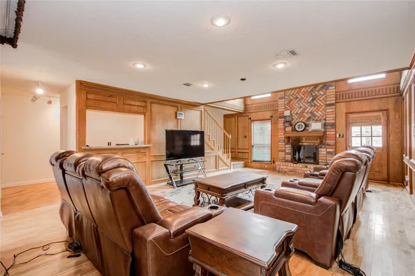 a living room with furniture a flat screen tv and a large window