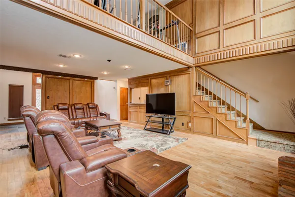 a living room with furniture a flat screen tv and kitchen view