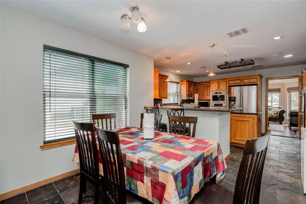 a dining room with a table chairs and a kitchen view
